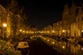 A night shot from the old bridge The Kerkbrug on the Oude Rijn with numerous boats and illuminated old canal-side houses, Leiden Royalty Free Stock Photo