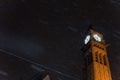 Night shot of an old clock tower with the dark sky in the background while snowing Royalty Free Stock Photo