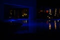 Night shot of a swimming pool, illuminated by its blue spotlights