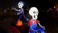 Night shot of two skeleton sculptures lighten from inside