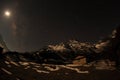 Night sky with clouds and stars passing by behind mountain Khumbila, Dole village. Nepal