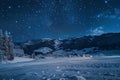 A night sky filled with stars shining over a snow-covered mountain, A picturesque winter landscape with a starry sky and Royalty Free Stock Photo