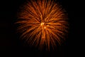 Delicate fireworks display in orange and gold against black sky Royalty Free Stock Photo