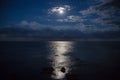 Full moon and reflection in sea, beautiful clouds. Royalty Free Stock Photo