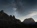 Night sky full of stars and Milky Way over desert like alpine landscape with prominent peaks, Italy Royalty Free Stock Photo