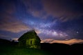 Night sky full of stars with some clouds and the milky way galaxy and an old rustic barn house in the foreground Royalty Free Stock Photo