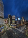 Night sky on the illuminated Ginza 4-Chome scramble crossing surrounding by buildings and skyscrapers.