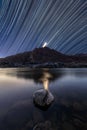 A night sky landscape with star trails, mountains and a river Royalty Free Stock Photo