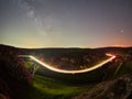 Night sky with milky way and stars, night road illuminated