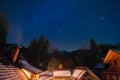 Night sky and stars above mountain cabins in winter