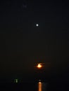 Night sky stars Pleiades Venus and Moon set observing over sea coast Royalty Free Stock Photo