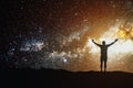 Night sky with stars cosmos and silhouette of a standing man with raised hands on the mountain. Landscape with Milky Way Royalty Free Stock Photo