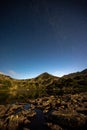 night sky with stars and hills of mountains in romanian mountain range retezat in carpathians in transylvania with the lake Royalty Free Stock Photo