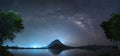 Night sky with stars and The Milky Way is above the mountain and reflection on the water