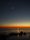 Night sky stars Pleiades Venus and Moon set observing over sea coast