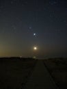 Night sky stars Pleiades Venus and Moon set observing over sea coast Royalty Free Stock Photo