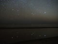 Night sky stars reflection, Orion Pleiades and Taurus constellation over sea Royalty Free Stock Photo