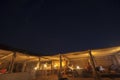 Night sky and tourists socializing in straw huts at night in Wahiba sands, Oman Royalty Free Stock Photo