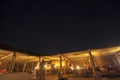 Night sky and tourists socializing in straw huts at night in Wahiba sands, Oman Royalty Free Stock Photo