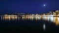 Night skyline of Chania town in Crete, Greece, illuminated buildings on sea promenade, full moon, starry sky Royalty Free Stock Photo