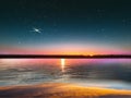 Blue bright starry sky on pink yellow sunset at sea water vawe reflection blurred light full moon moonlight  skyline  nebula natur Royalty Free Stock Photo