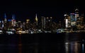 Night skyline of New York City, illuminated by vibrant lights.