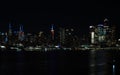 Night skyline of New York City, illuminated by vibrant lights.