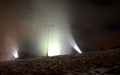 Night snowfall artificial snow on a ski slope with snow cannons. It shines on a stream of freezing snowflakes against the night sk Royalty Free Stock Photo