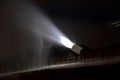 Night snowfall artificial snow on a ski slope with snow cannons. It shines on a stream of freezing snowflakes against the night sk Royalty Free Stock Photo