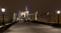 Night snowy colorful Prague Lesser Town with gothic Castle, St. Nicholas` Cathedral from Charles Bridge, Czech republic Royalty Free Stock Photo