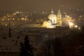 Night snowy foggy Prague City with St. Nicholas' Cathedral, Czech republic