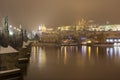 Night snowy Prague gothic Castle with Charles Bridge and St. Nicholas' Cathedral , Czech republic Royalty Free Stock Photo