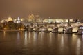 Night snowy Prague gothic Castle with Charles Bridge and St. Nicholas' Cathedral , Czech republic Royalty Free Stock Photo