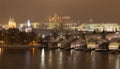 Night snowy Prague gothic Castle with Charles Bridge and St. Nicholas' Cathedral , Czech republic Royalty Free Stock Photo