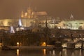 Night snowy Prague gothic Castle with Charles Bridge and St. Nicholas' Cathedral , Czech republic Royalty Free Stock Photo