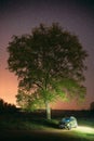 Night Starry Sky Above Car Renault Duster. SUV parked near lonely tree in night forest.