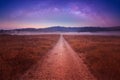 Night Starry Sky Above Country Road In Countryside And Green Field. Night View Of Natural Glowing Stars. Red Ground In Red Light Royalty Free Stock Photo