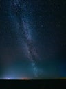 Night Starry Sky Above Field And Yellow City Lights On Background Royalty Free Stock Photo