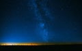 Night Starry Sky Above Field And Yellow City Lights On Background Royalty Free Stock Photo