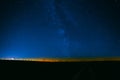 Night Starry Sky Above Field And Yellow City Lights On Background Royalty Free Stock Photo