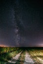 Night Starry Sky With Milky Way Glowing Stars Above Country Road In Countryside And Green Field Landscape Royalty Free Stock Photo