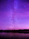 Night starry sky over a small lake.