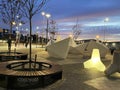 Night street art , neon blurred light, blue sky and moon,  modern installation as white ship  decoration, people walk and relax in Royalty Free Stock Photo