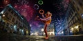 Night street circus performance whit clown, juggler. Festival city background. fireworks and Celebration atmosphere. Wide engle Royalty Free Stock Photo