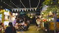 Night street food market in Bangkok, Thailand bustling with shoppers and vendors