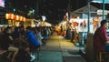 Night street food market in Bangkok, Thailand bustling with shoppers and vendors