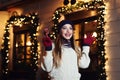 Night street portrait of young beautiful woman acting thrilled, wearing stylish knitted clothes. Model expressing joy Royalty Free Stock Photo