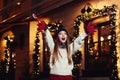 Night street portrait of young beautiful woman acting thrilled, wearing stylish knitted clothes. Model expressing joy Royalty Free Stock Photo