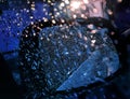 Night street. Side view mirror of motor vehicle covered in raindrops.