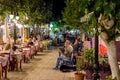 Night street with tavernas full of tourists and street musicans at Paleochora town in west part of Crete island. Royalty Free Stock Photo